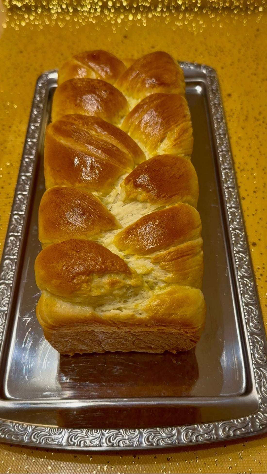 Goldbraun gebackenes geflochtenes Topfen-Brioche auf einem silbernen Tablett