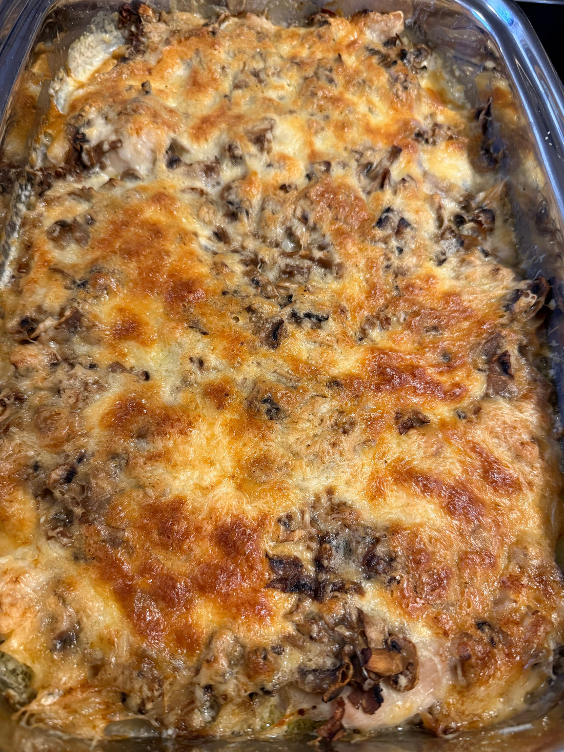 Mit Käse und Champignons überbackene Schnitzel, goldbraun gratiniert in einer Auflaufform